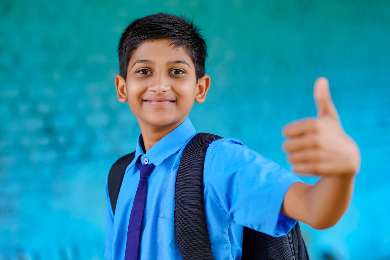 A confident schoolboy giving a thumbs up